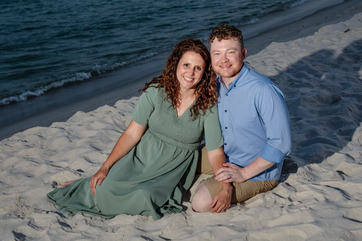 Orange beach photographer Sample Photos 19 Couple sitting by the water's edge during a professional photo session in Orange Beach, Alabama.