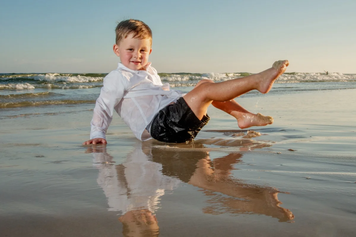 Orange beach photographer Sample Photos 6 Young boy playing by the water's edge during an Orange Beach family portrait session.