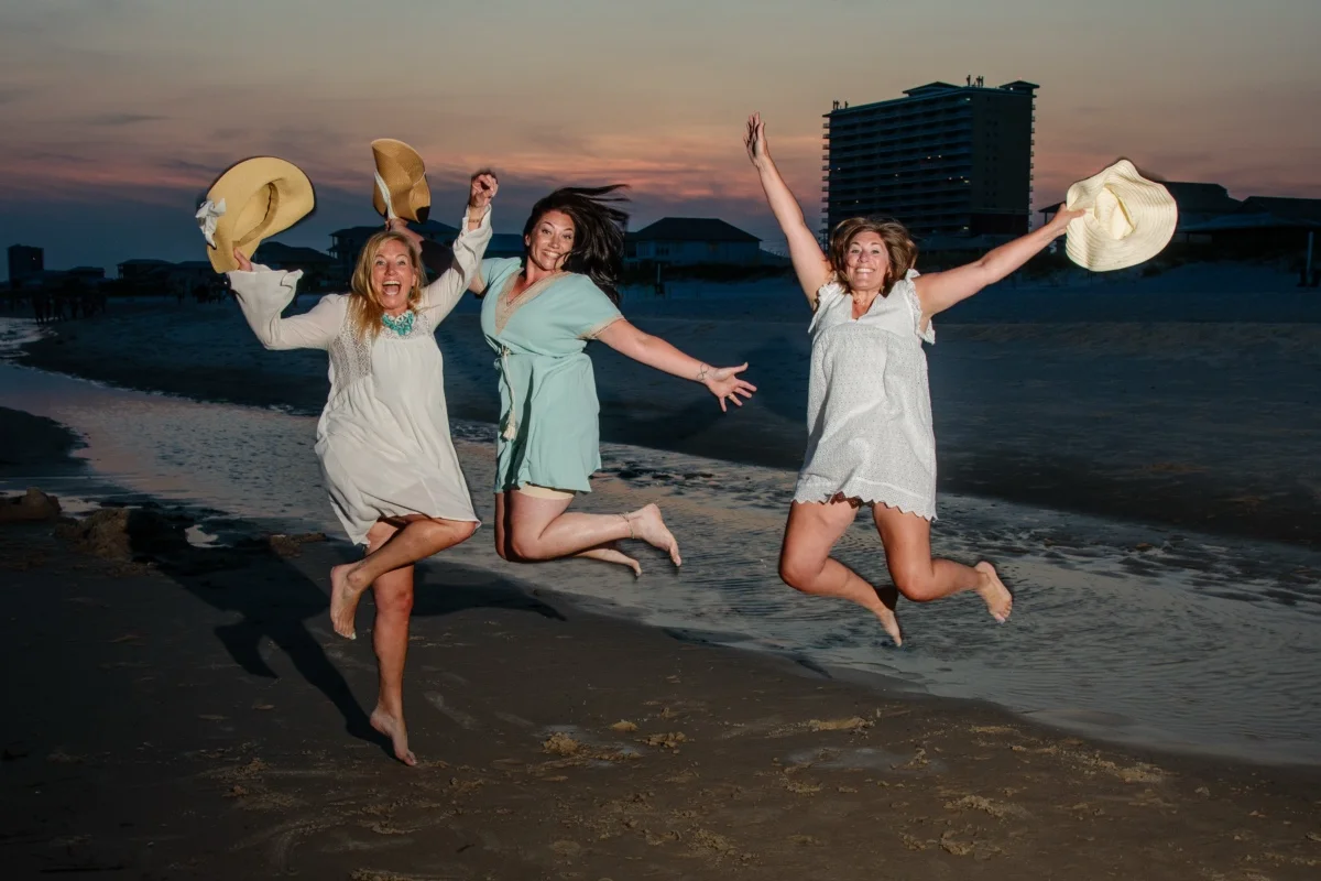 Orange beach photographer Sample Photos 5 Three girls jumping in the air having fun at sunset during their photo session in Orange Beach, Alabama. in Orange Beach, Alabama.