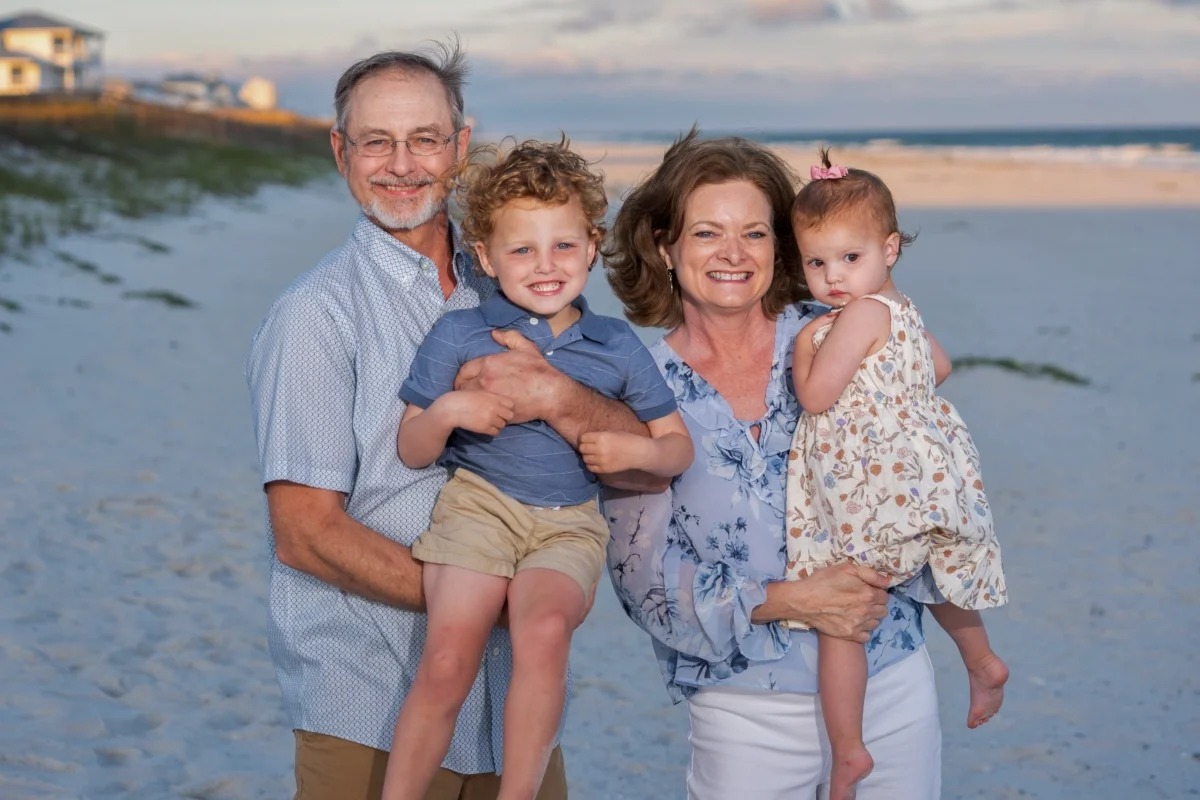 Orange beach photographer Sample Photos 14 Four people standing on the beach in Orange Beach, Alabama during a professional photo session.